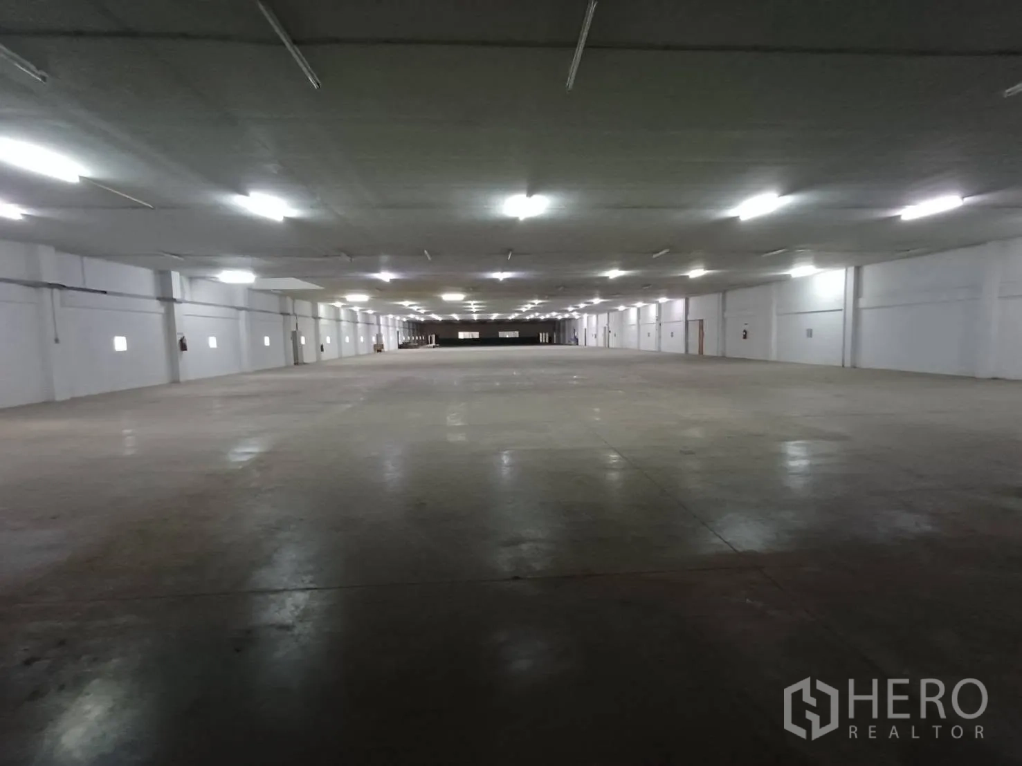 Warehouse for rent in Mueang Samut Prakan, Samut Prakan - Bright warehouse interior showing continuous lighting grid over a concrete floor.
