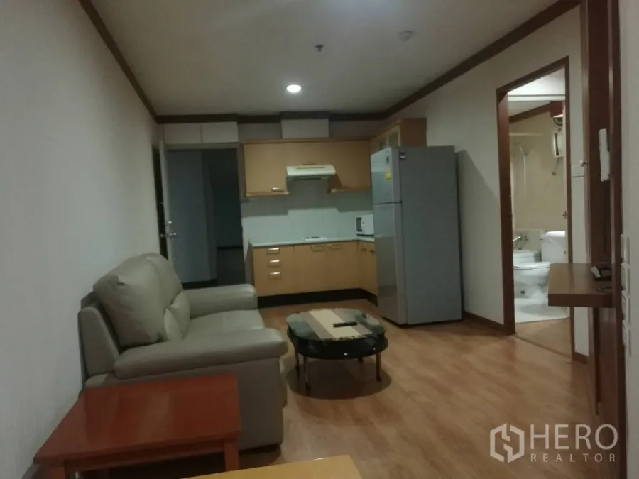 คอนโด ให้เช่าในKhlong Toei, Bangkok - ห้องนั่งเล่นแบบเปิดโล่ง พื้นไม้ โซฟา และครัวพร้อมตู้เย็น