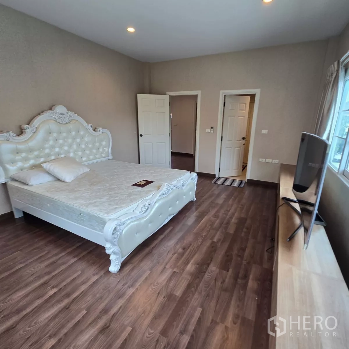 บ้าน ให้เช่าในMueang Pathum Thani, Pathum Thani - ห้องนอนที่สอง เตียงหัวเตียงลายหลุยส์ พื้นไม้ และชั้นวางทีวี