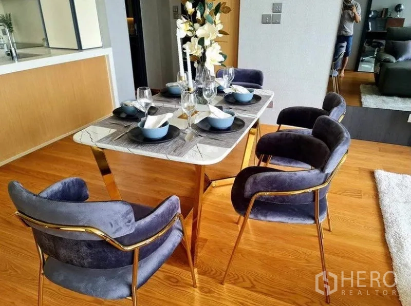 公寓 出租在Khlong Toei, Bangkok - 大理石餐桌配天鹅绒餐椅与精致餐具。