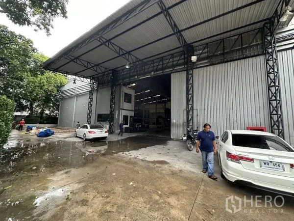 工厂 出租在Bang Bua Thong, Nonthaburi - 高挑钢结构雨棚的装卸区，大型卷帘门入口。