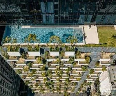 คอนโด ให้เช่า - ภาพมุมสูงอาคารคอนโดพร้อมสระว่ายน้ำและสวนลอยฟ้า