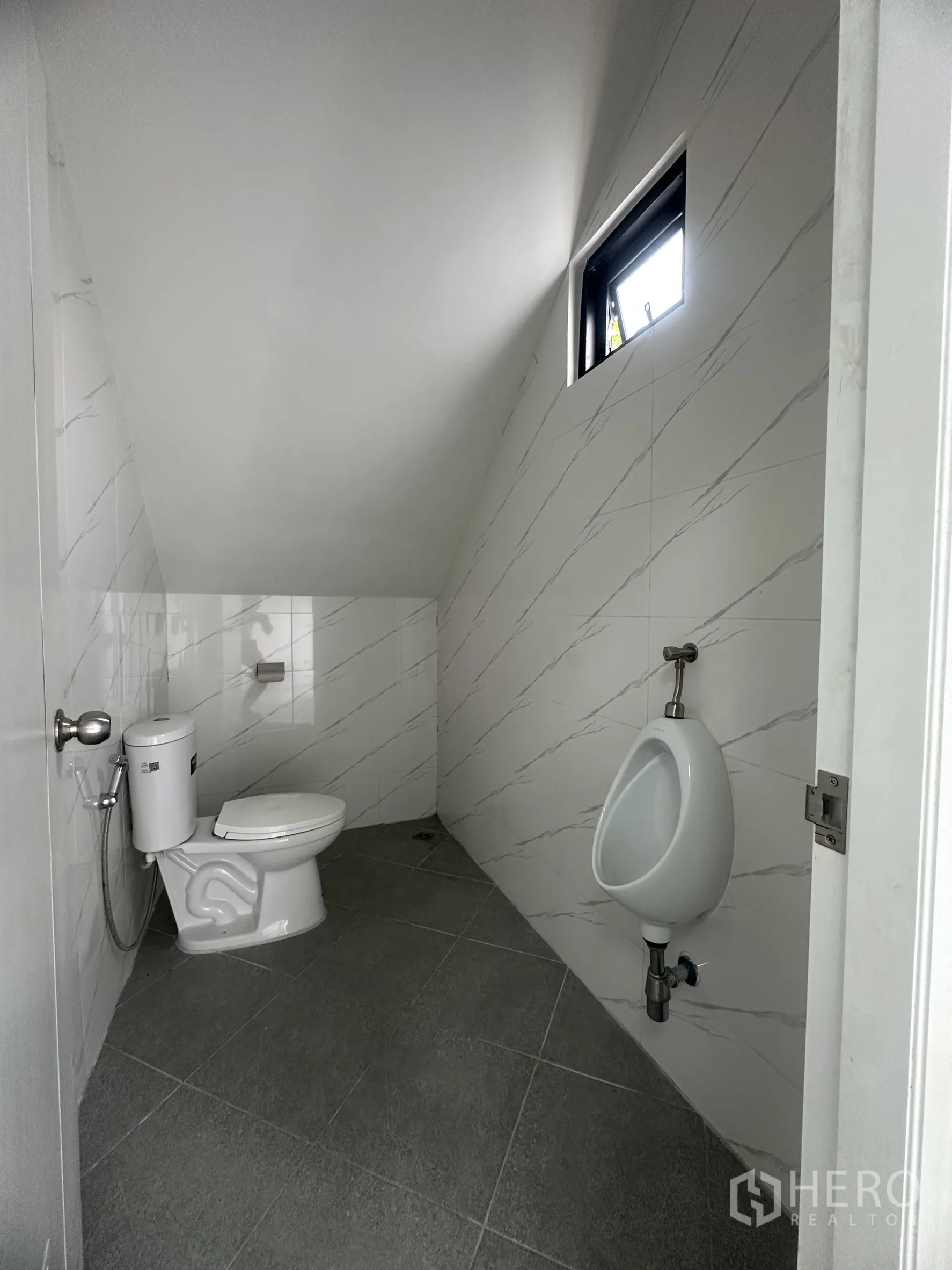 货栈 出售在Khlong Luang, Pathum Thani - 一层卫生间，配坐便、挂式小便器与大理石纹墙砖。