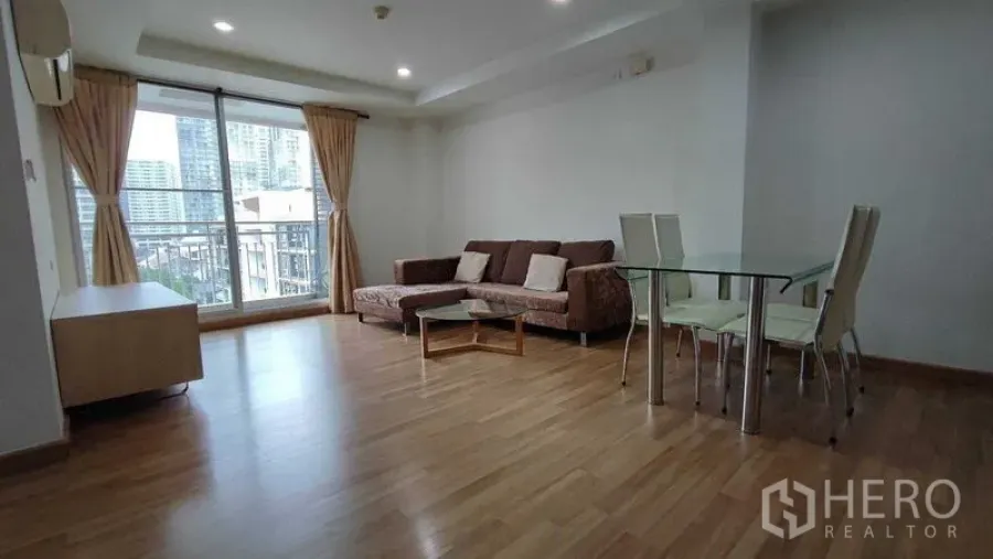 คอนโด ให้เช่าในKhlong Toei, Bangkok - ห้องนั่งเล่นและทานอาหารสว่าง พื้นไม้ โซฟา โต๊ะกระจก พร้อมระเบียงวิวเมืองในคอนโดกรุงเทพฯ