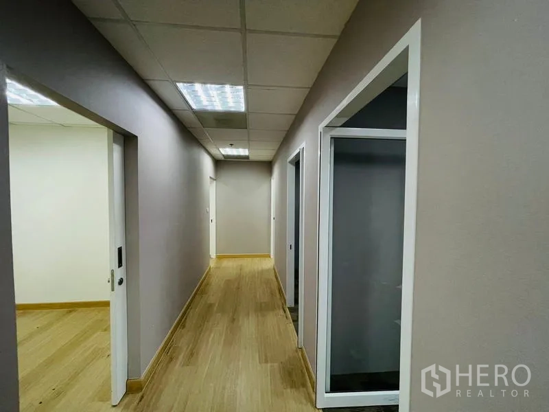 Office Space for rent - Hallway with recessed lighting and doors to separate offices.