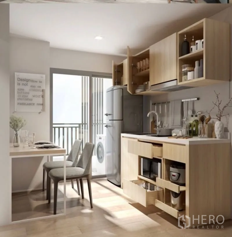 公寓 出售在Phra Khanong, Bangkok - 浅木色橱柜的紧凑厨房，设早餐桌，并连接带洗衣区的阳台。