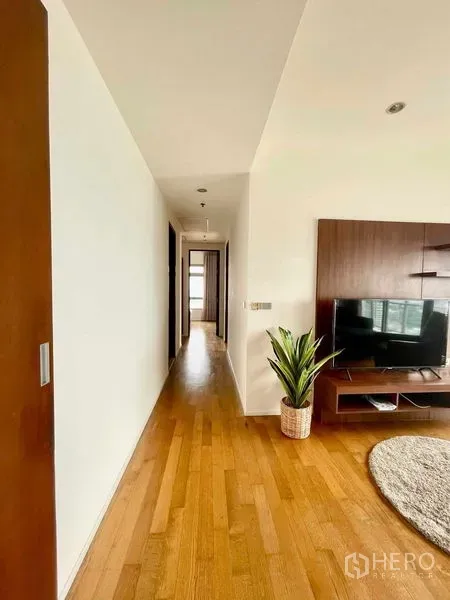 คอนโด ให้เช่าในWatthana, Bangkok - โถงทางเดินพื้นไม้เชื่อมไปยังห้องนอน เห็นชุดทีวีในห้องนั่งเล่น