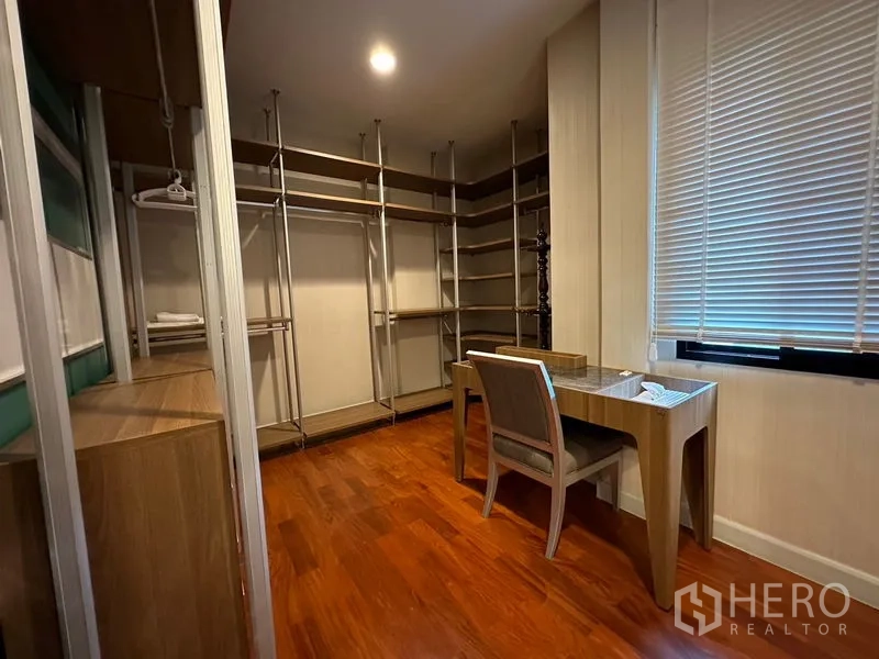 Detached House for rent or sale in Khan Na Yao, Bangkok - Walk-in closet with open shelving, hanging rails, desk and window blind.