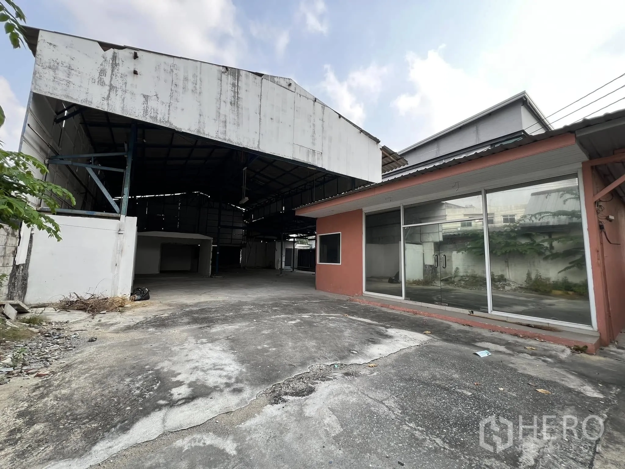 โกดัง for rent in Lat Phrao, Bangkok - มุมมองด้านหน้าโกดังหลังคาเหล็กแบบเปิดข้าง พร้อมออฟฟิศกระจกและลานคอนกรีต