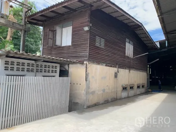 Warehouse for rent in Yan Nawa, Bangkok - Attached office building with wooden upper level beside the warehouse and a gated lane.