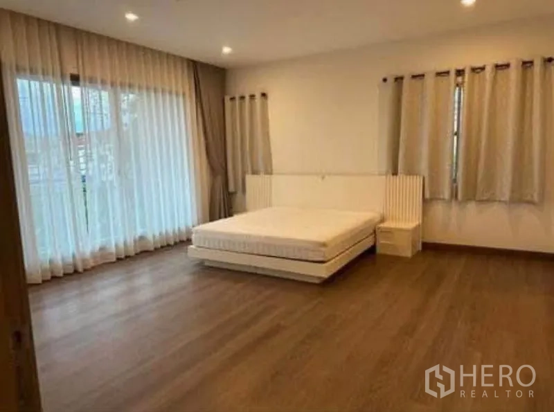 บ้าน ให้เช่า - ห้องนอนหลักมีฐานเตียง พื้นไม้ และทางออกสู่ระเบียง