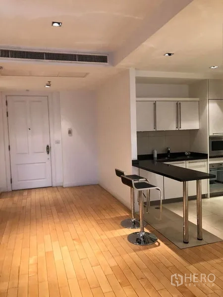 Condominium for rent in Pathum Wan, Bangkok - Entry space with wood flooring and breakfast bar connecting to the kitchen.
