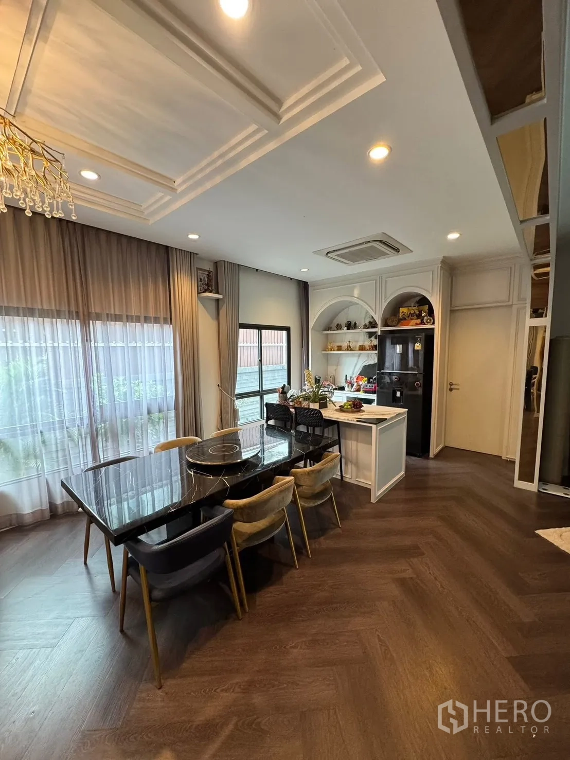 独立式住宅 出售在Mueang Pathum Thani, Pathum Thani - 餐厅配黑色大理石餐桌、六把椅子与中岛。