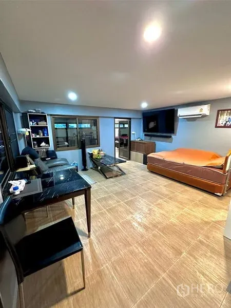 Detached House for sale in Bang Bua Thong, Nonthaburi - Open-plan living area with sofa set, wall-mounted TV, dining table and tiled floors.