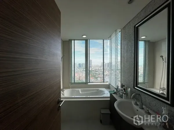 คอนโด ขายในKhlong San, Bangkok - ห้องน้ำสไตล์โมเดิร์นพร้อมอ่างอาบน้ำติดหน้าต่าง วิวเมือง ม่านบังตา และอ่างล้างหน้า.