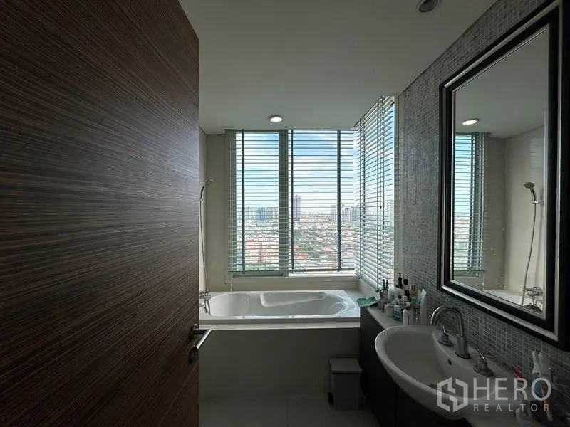 คอนโด ขายในKhlong San, Bangkok - ห้องน้ำสไตล์โมเดิร์นพร้อมอ่างอาบน้ำติดหน้าต่าง วิวเมือง ม่านบังตา และอ่างล้างหน้า.