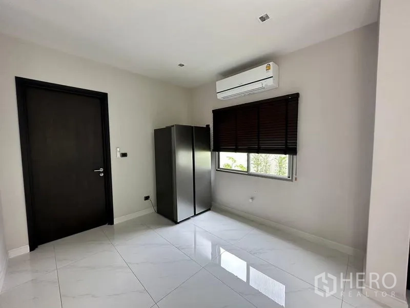 Detached House for rent in Bang Phli, Samut Prakan - Spare bedroom with glossy tile floors, window blinds, a wardrobe and wall-mounted air conditioner.