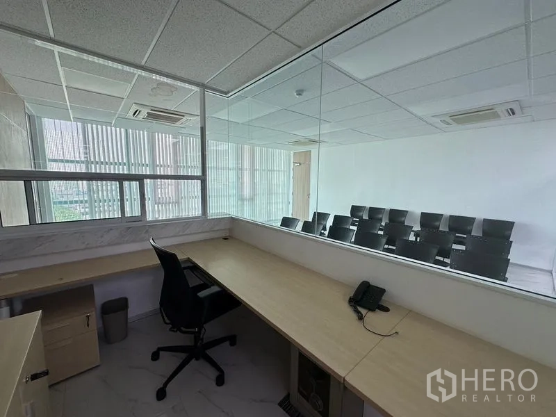 Office Space for rent - Control or reception room with built-in counter facing a training room through a large observation window.