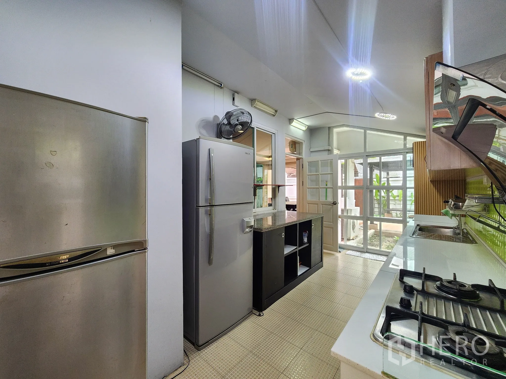 独立式住宅 出租在Bang Kapi, Bangkok - 廊式厨房，燃气灶、双门冰箱并可通后院。