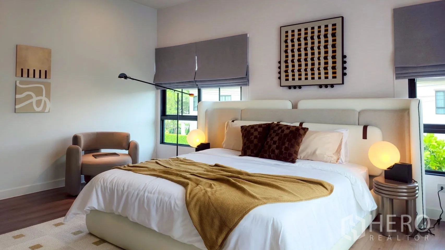 Detached House for rent in Bang Phli, Samut Prakan - Sunlit bedroom with large windows, white upholstered headboard, and accent armchair.
