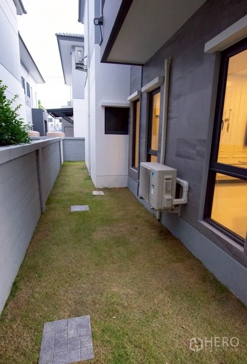 Detached House for rent in Bang Phli, Samut Prakan - Front garden with landscaping, shrubs and large windows.