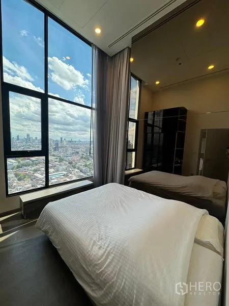 公寓 出租在Ratchathewi, Bangkok - 卧室配落地窗与城市景观，内有两张床。