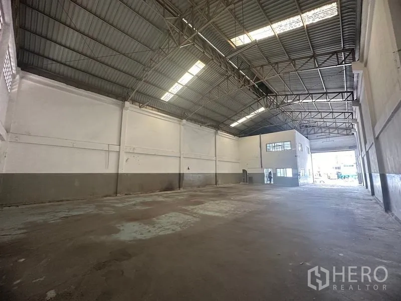 Factory for rent in Khlong Luang, Pathum Thani - High-clear warehouse interior with steel truss roof and skylight panels.
