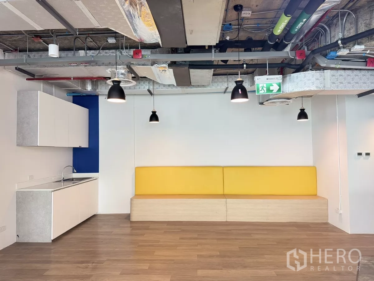 办公空间 出租在Din Daeng, Bangkok - 茶水间与休息区，黄色座椅、吊灯与木地板。