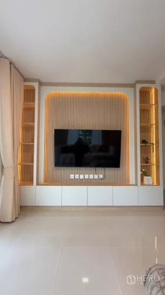 บ้าน ให้เช่าในBang Phli, Samut Prakan - ผนังทีวีบิวท์อินในห้องนั่งเล่นพร้อมชั้นวางและทีวีขนาด 65 นิ้ว.