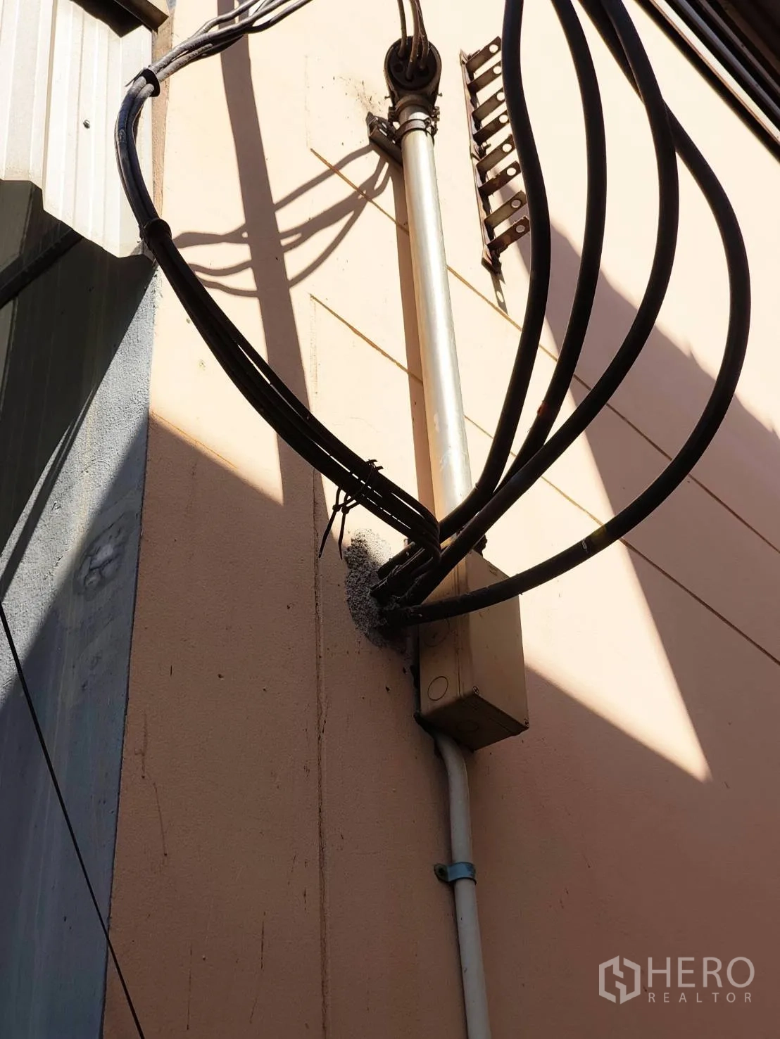 Factory for rent in Krathum Baen, Samut Sakhon - Heavy-duty power cables and a junction box fixed to the exterior wall.