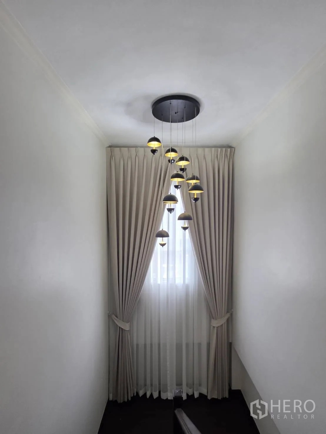 Detached House for sale in Lam Luk Ka, Pathum Thani - Stair landing featuring hanging pendant lights and double-layer curtains.