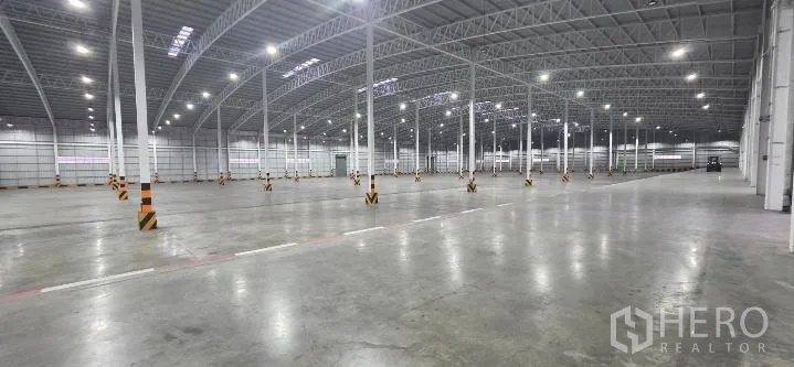 Factory for rent in Si Racha, Chon Buri - Vast empty warehouse hall with bright lighting and wide concrete floor.