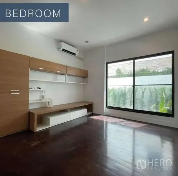 独立式住宅 出售在Khlong Toei, Bangkok - 明亮卧室，木地板与内置柜，大窗面向花园。