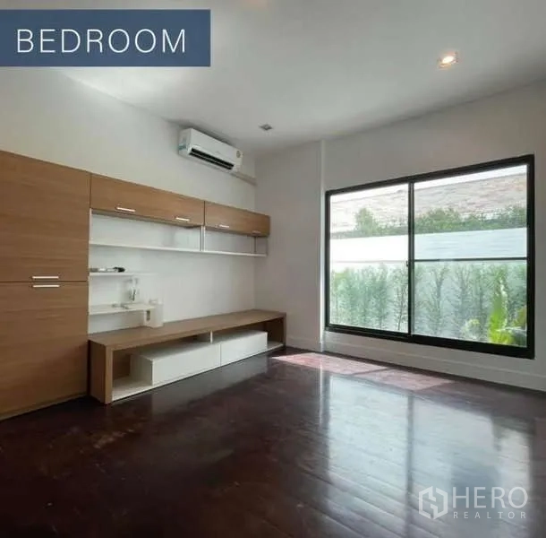 独立式住宅 出售在Khlong Toei, Bangkok - 明亮卧室，木地板与内置柜，大窗面向花园。