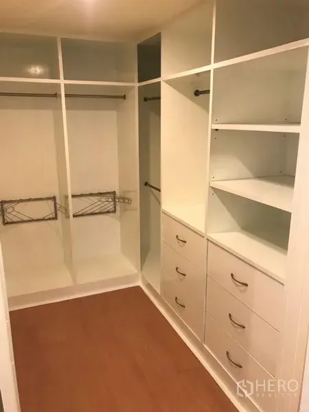 Condominium for rent in Watthana, Bangkok - Spacious walk-in closet with white built-in shelves, drawers and hanging rails.