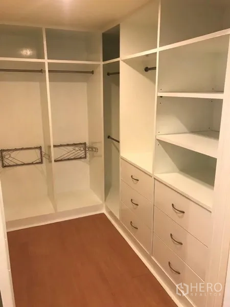 Condominium for rent in Watthana, Bangkok - Spacious walk-in closet with white built-in shelves, drawers and hanging rails.
