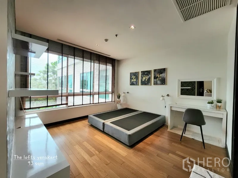 Condominium for rent in Yan Nawa, Bangkok - Bright master bedroom with corner windows, platform bed base, desk, and blinds in a modern Bangkok condominium.
