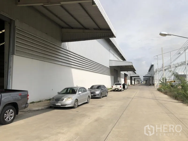 工厂 出租在Wang Noi, Phra Nakhon Si Ayutthaya - 多栋仓库外立面排布，配大雨棚与路侧停车位。