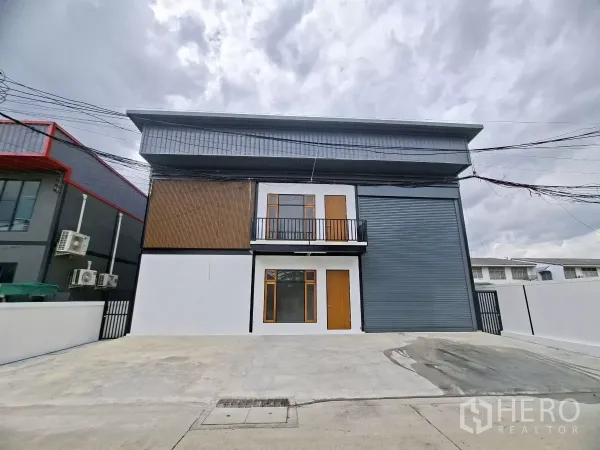 货栈 出租在Lam Luk Ka, Pathum Thani - Lam Luk Ka 区 Lat Sawai 现代迷你工厂型仓库外观，设大卷闸门、阳台办公室与宽阔混凝土停车区。