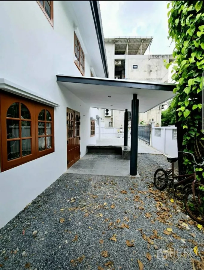 สำนักงานที่บ้าน ให้เช่าในLat Phrao, Bangkok - เฉลียงหน้าบ้านหลังคากันสาด พื้นโรยหิน และม้านั่งข้างประตูไม้บานคู่