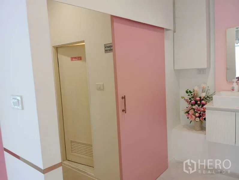 零售空间 出租在Watthana, Bangkok - 洗手区，粉色推拉门、台上盆与花饰。