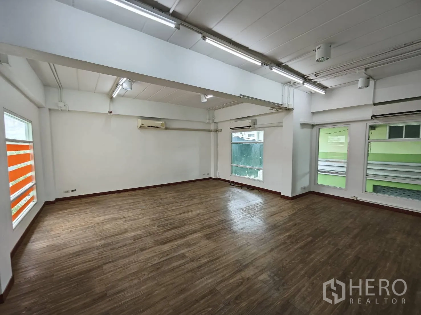 Office Space for rent in Prawet, Bangkok - Large white office with ceiling lights, multiple windows and AC units.