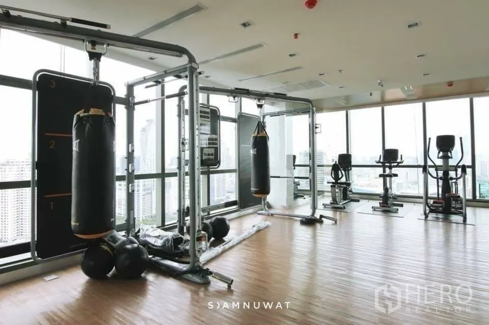 คอนโด for rent in Ratchathewi, Bangkok - ฟิตเนสพร้อมกระสอบทราย เครื่องออกกำลังกาย และวิวเมืองผ่านกระจก