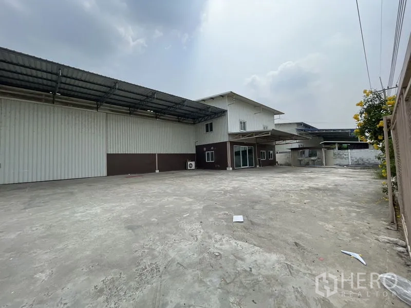 Warehouse for rent in Lat Lum Kaeo, Pathum Thani - Spacious yard beside the metal warehouse and office block with awnings for truck access.