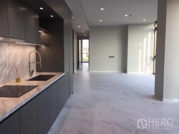 Condominium for rent in Watthana, Bangkok - Open-plan Thonglor condo showing sleek grey kitchen with marble countertop and bright living area.