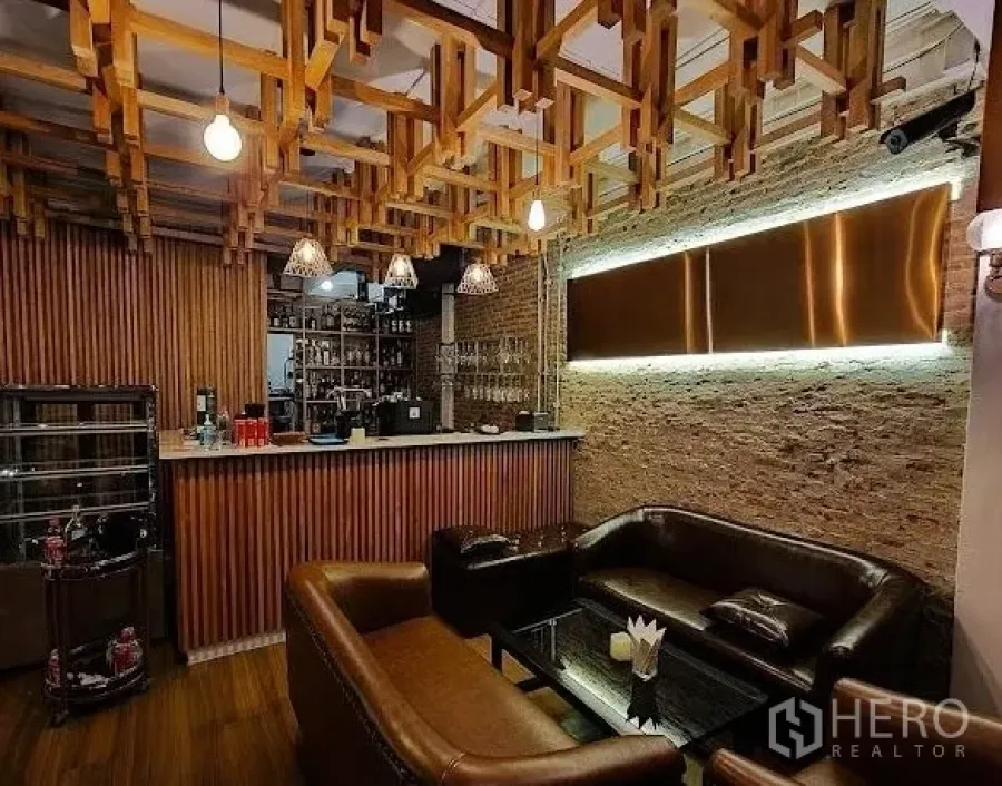 พื้นที่ขายปลีก ให้เช่า - เคาน์เตอร์บาร์กับโซฟาหนังและฝ้าไม้ลวดลายในพื้นที่รีเทล