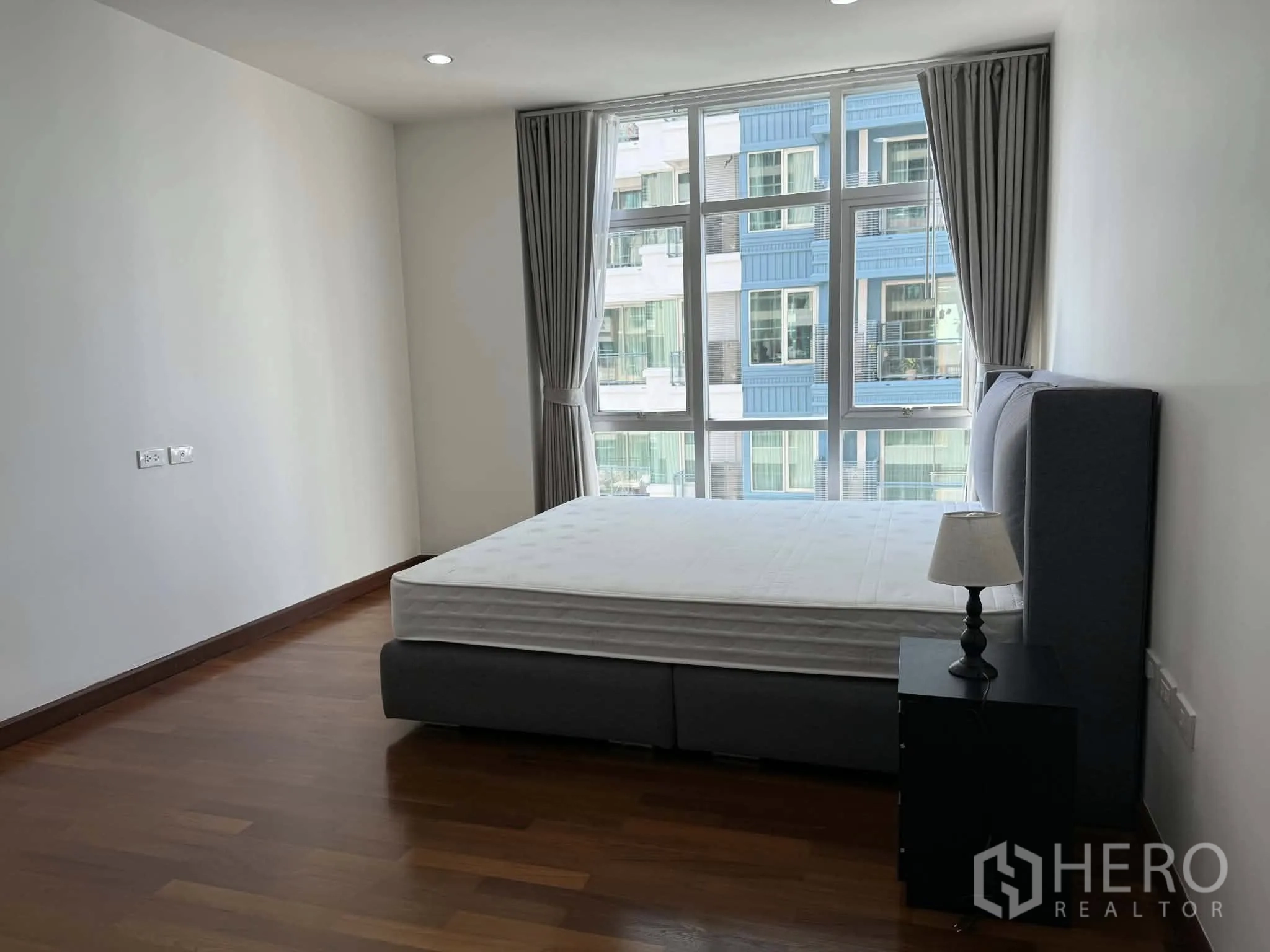 公寓 for rent in Pathum Wan, Bangkok - 卧室配软包床、床头柜与大幅窗户。