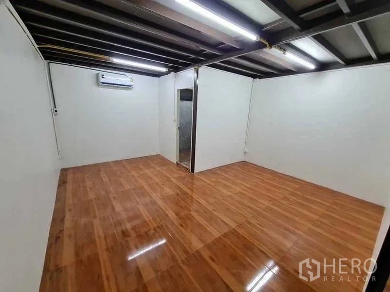 Warehouse for rent in Prawet, Bangkok - Enclosed office room with glossy wooden floor, split-type air conditioner and lighting.