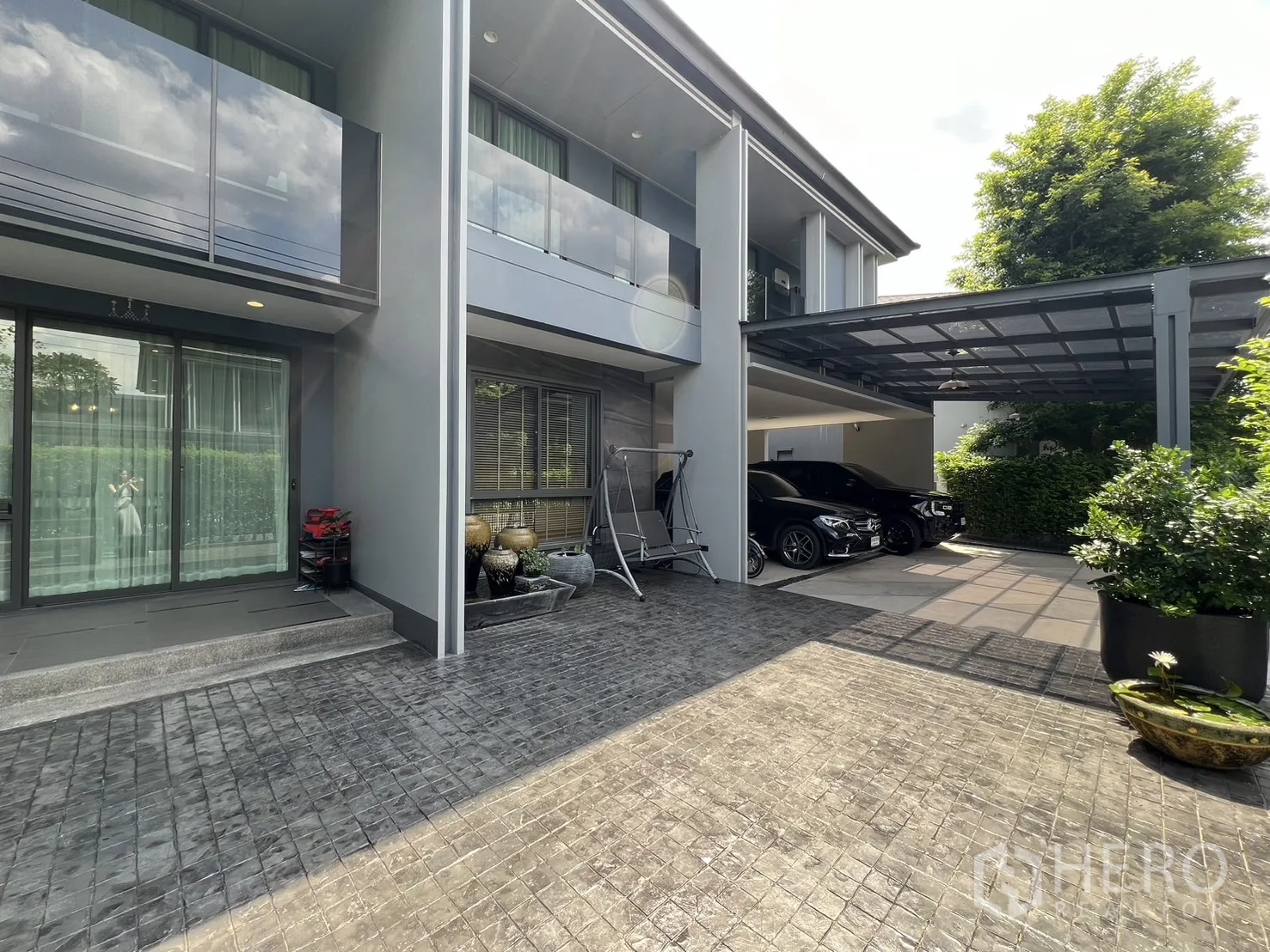 Detached House for rent or sale in Bang Kapi, Bangkok - Front yard with bench table set and tall hedge for privacy.