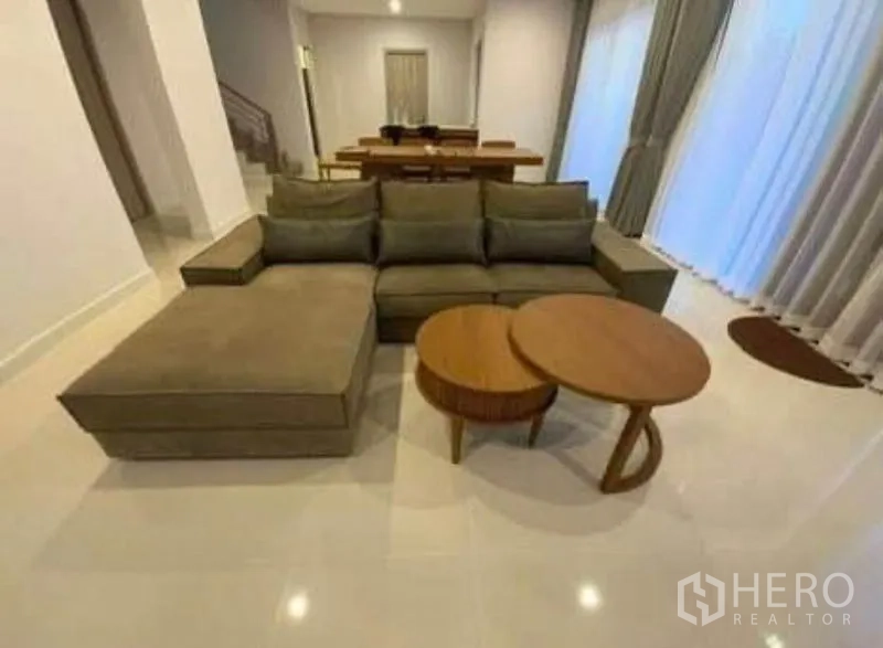 บ้าน ให้เช่า - โซนนั่งเล่นแบบโอเพนแพลน โซฟาเข้ามุมและโต๊ะกาแฟทรงกลม